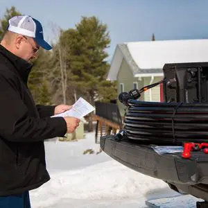 Heat-Line on Tailgate with Contractor reading self-regulating heat trace cable installation instructions