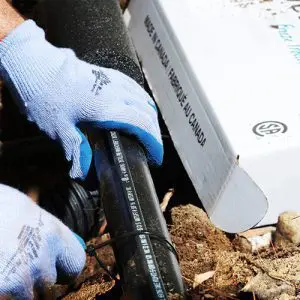 Contractor installing external self-regulating heat trace system to pipe outdoors