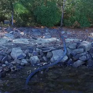 Water supply pipe on land to lake with stand at bottom of lake
